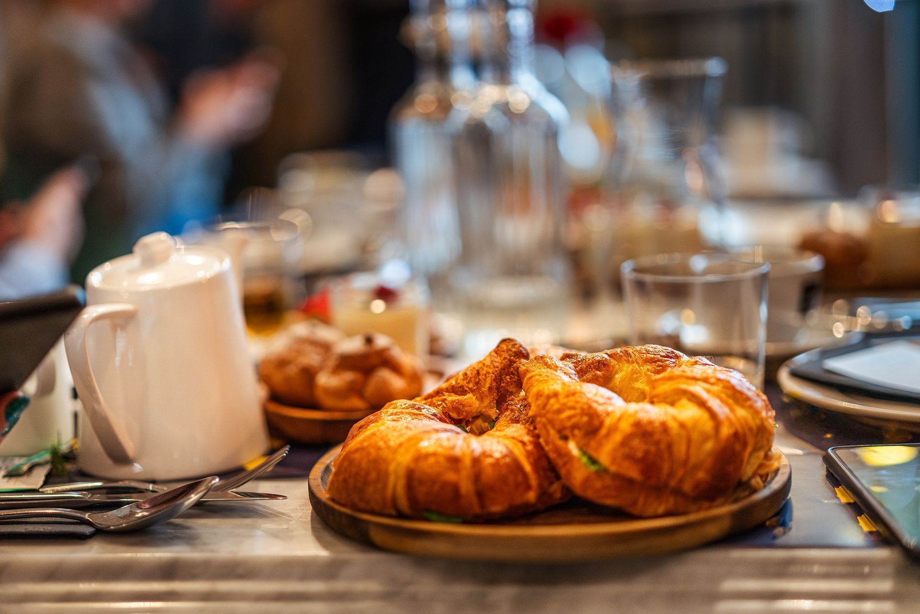 Fresh croissants served on a wooden board at a cafe table