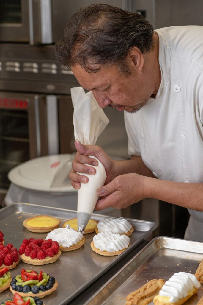 Pastry chef decorating fruit tarts